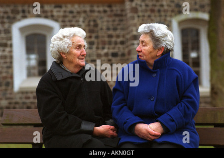 Due donne anziane seduta su una panchina Foto Stock