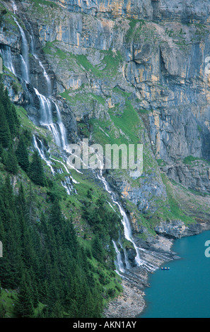 La cascata e canoa nel lago Oeschinensee vicino a Kandersteg Oberland Overland svizzera Foto Stock