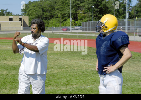 Alta Scuola Calcio azione Port Huron Michigan sordi JV giocatore di football legge la lingua dei segni data dal nero aiuto durante la pratica Foto Stock