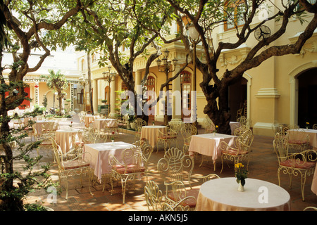 Cortile ombreggiato tavolini dei caffè presso l'Hotel Continental, Dong Khoi St, a Saigon, a Ho Chi Minh City, Viet Nam Foto Stock