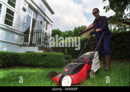 Uomo di falciare un prato nel suo giardino, Verden, Germania Foto Stock