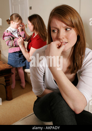 Madre tergi lacrime dai suoi giovani figlie occhi e preoccupato del giovane donna in primo piano Foto Stock