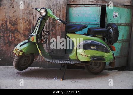 Un verde scooter parcheggiato contro il blu pareti dettagliata di Jodhpur, India Foto Stock