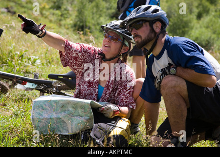 Uomo e donna che guarda la mappa topo con caschi moto su in Crested Butte, Colorado Foto Stock