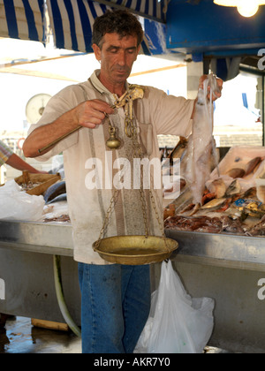 Sicilia Italia Mercato del Pesce a Porticello uomo del peso di pesce con scale in ottone Foto Stock