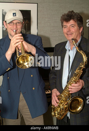 Due musicisti con strumenti saxsophone e tromba chiacchiere e giocare davanti a un poster con immagine di un musicista jazz Foto Stock