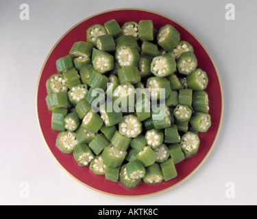 Medley di fettine di green okra pezzi su oro rosso piastra rim verdure congelate Bon Appetit Foto Stock
