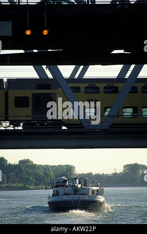 Navigazione sui fiumi olandese una nave incrocio sotto un ponte ferroviario Foto Stock