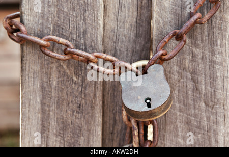 Vecchia serratura e la catena intorno alla recinzione di legno Foto Stock