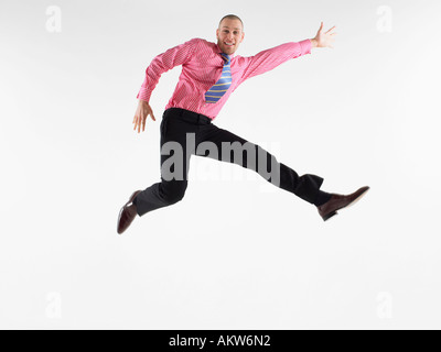 Businessman jumping in studio Foto Stock