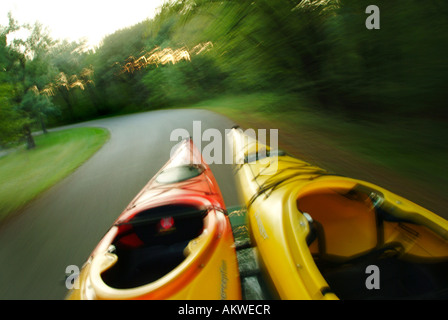 Kayak su un portabagagli per tetto come l'unità auto giù per una strada tortuosa Foto Stock