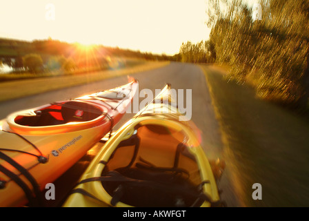 Kayak su un portabagagli per tetto come l'unità auto giù per una strada tortuosa Foto Stock
