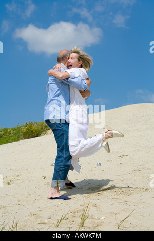 Coppia matura giocando a bocce, abbracciando Foto Stock