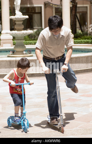 Asian padre figlio di insegnamento per un giro in scooter Taiwan Cina Foto Stock