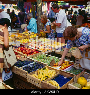 People Shopping e guardando un display di frutti in un vivace mercato locale nel sud della Francia Foto Stock