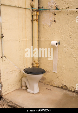 Angolo di un vecchio wc esterno metà demolito con solo due pareti a sinistra in piedi nel villaggio Braunton Devon England Foto Stock