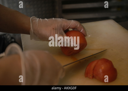 Un chef mani cubettatura fino un pomodoro. Foto Stock