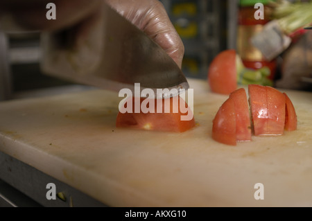 Un chef mani cubettatura fino un pomodoro. Foto Stock