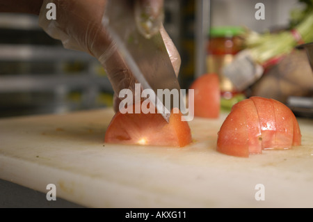 Un chef mani cubettatura fino un pomodoro. Foto Stock