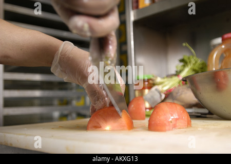 Un chef mani cubettatura fino un pomodoro. Foto Stock