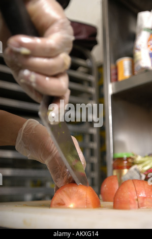 Un chef mani cubettatura fino un pomodoro. Foto Stock