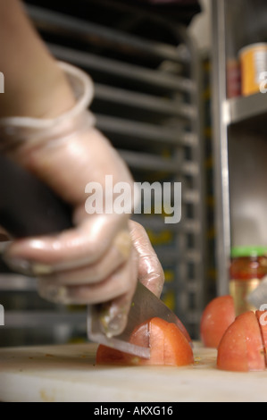 Un chef mani cubettatura fino un pomodoro. Foto Stock