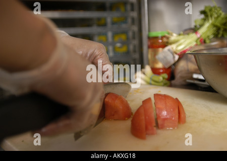 Un chef mani cubettatura fino un pomodoro. Foto Stock