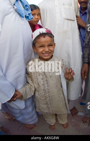 Un giovane ragazzo musulmano si erge con i suoi zii a la Jama Masjid moschea di Vecchia Delhi, India. Foto Stock