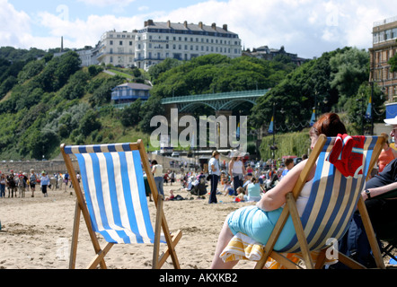 Sedie a sdraio e una folla di vacanzieri in Scarborough Beach Foto Stock