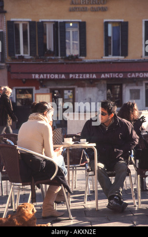 Venezia , Italia. Una giovane coppia godendo il sole invernale sul Campo Santa Margherita nel sestiere di Dorsoduro. Foto Stock