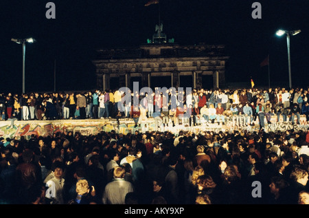 Caduta del muro di Berlino: persone da Berlino Ovest e Berlino Est salendo sulla parete presso la Porta di Brandeburgo il 9 novembre 1989, Foto Stock