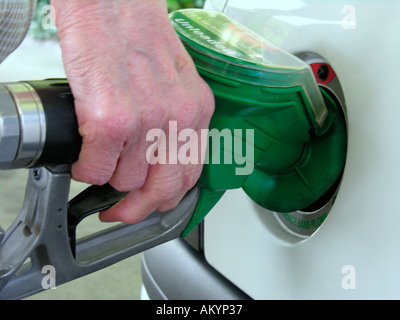 Donna anziana riempiendo la sua vettura a benzina Foto Stock