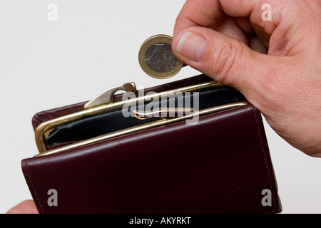 La borsetta e una mano che tiene una moneta Foto Stock