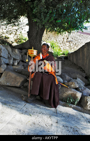 Frate con un mulino di preghiera, monastero di Drepung vicino a Lhasa, in Tibet, in Asia Foto Stock