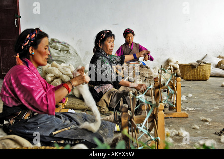 Donne tibetane con un arcaico ruote di filatura, la fabbricazione di tappeti, Shigatse, nel Tibet, Asia Foto Stock