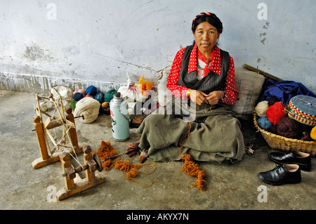 Donna tibetana con un arcaico ruota di filatura, la fabbricazione di tappeti, Shigatse, nel Tibet, Asia Foto Stock