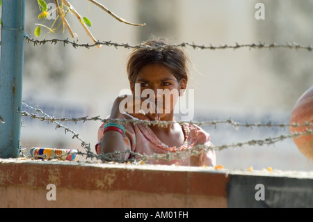 Un giovane di dalit o intoccabile, ragazza sguardi longingly nel cortile del villaggio di governo scuola in Nimaj, India. Foto Stock