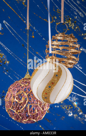 Festa di Natale Le sfere pendenti sulla composizione decorativa blu inverno sfondo con brillantini e stelle Foto Stock