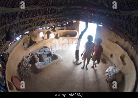 Giovani ragazzi dentro la loro casa nelle dune del grande deserto di Thar vicino Manvar Rajasthan in India Foto Stock