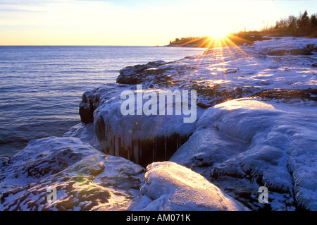 Lago Superiore ricoperta di ghiaccio costa rocciosa di sunrise Grand Marais MN Foto Stock