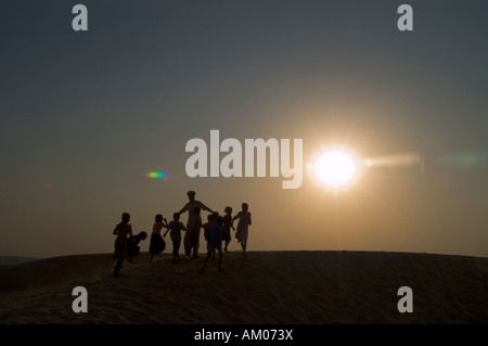 Balwant Singh gioca con i bambini del villaggio nelle dune del grande deserto di Thar al di fuori di Manvar Rajasthan in India Foto Stock