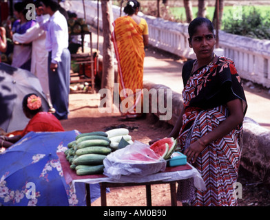 Donna vendita di acqua melone al di fuori del tempio indù a Ponda a Goa nel sud dell'India Foto Stock