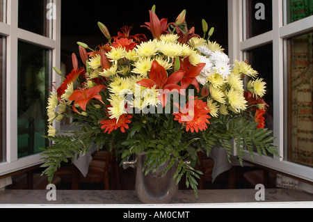 Vista ravvicinata di un autunno bouquet di fiori nella parte anteriore di un ristorante aperto la finestra Foto Stock
