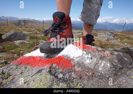 Piede di un bambino su una pietra con il rosso e il contrassegno bianco Foto Stock