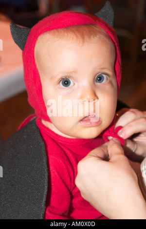 Adorabile bambino vestito come un piccolo diavolo per Halloween, festeggiando negli Stati Uniti. Foto Stock