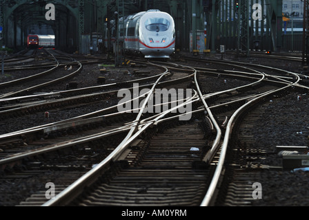 Ferrovie e treno in arrivo nella stazione centrale di Colonia Foto Stock