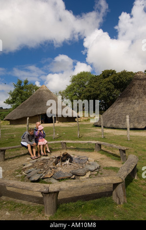 Tre persone che visitano Castell Henllys ricostruito in età di ferro hill fort Pembrokeshire Wales UK Foto Stock