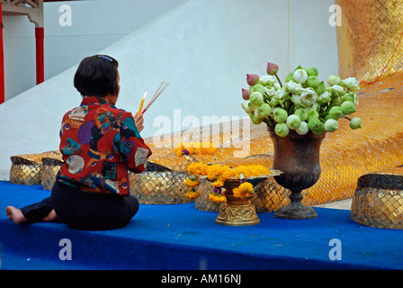 La preghiera nella parte anteriore della statua del Buddha, Wat Intharawihan, Bangkok, Thailandia Foto Stock