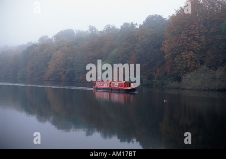 Red cruiser narrowboat sul Fiume Tamigi prima di Hart di blocco del legno in autunno nei pressi di Whitchurch Oxfordshire Inghilterra Foto Stock