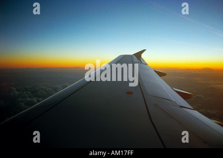 La vista al di fuori di un aeromobile oblò affacciato sul parafango, all'alba Foto Stock